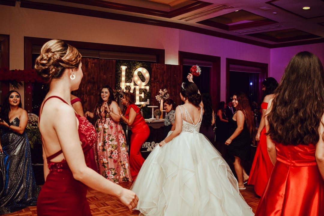 Bride tosses a bouquet to guests at a wedding reception.